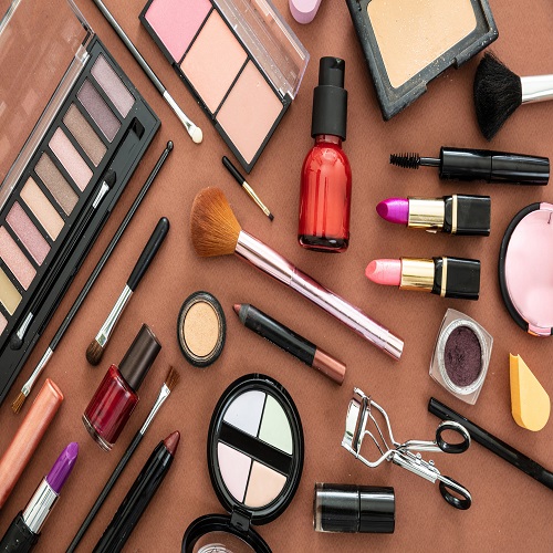 Make up cosmetics flat lay. Lipstick and nail polish, eye shadows and blush, brushes and pencils against brown  color background